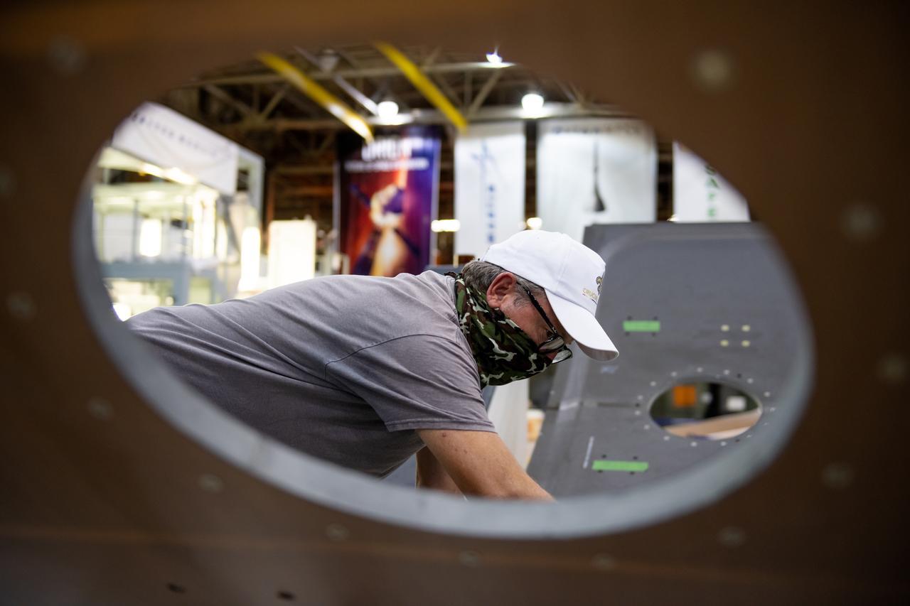 Employees wear personal protective gear at  Michoud Assembly Facility as the facility transitioned to Stage 3 of NASA’s Framework for Return To On-Site Work. Employees wear the appropriate personal protective equipment (PPE) and/or cloth face coverings as required for assigned tasks. Access to the facility is limited to authorized personnel working on mission-critical tasks that must be conducted onsite. Mission-critical tasks include slowly and methodically resuming Space Launch System (SLS) Core Stage and Orion production activities, particularly critical path deliverables to support the Artemis Program, at a pace that limits personnel and follows federal guidelines for social distancing and use of personal protective equipment such as face masks. For more information about SLS, visit nasa.gov/sls.